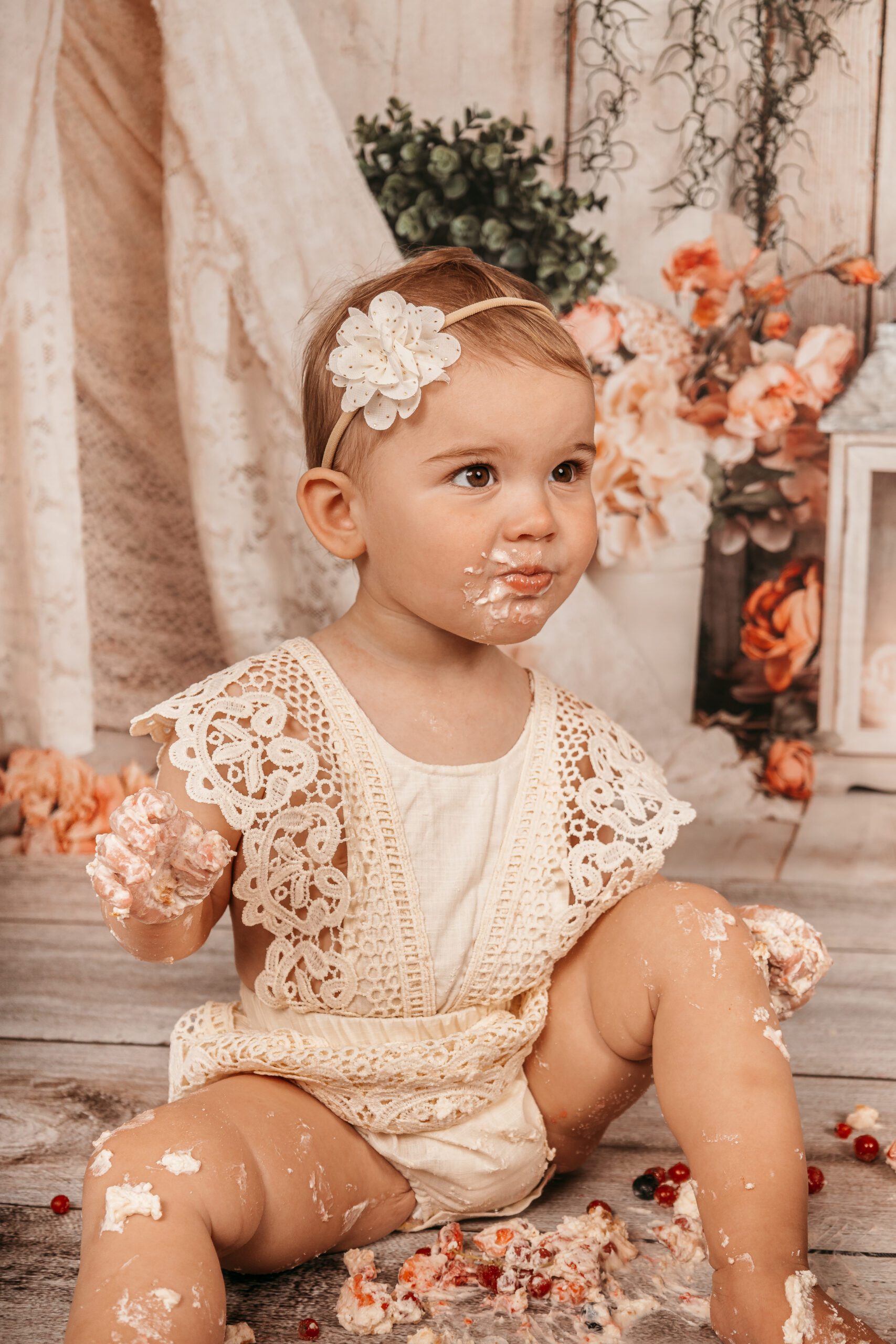 Baby mit zermatschtem Kuchen beim Cakesmash Shooting